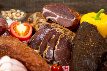Assortment of cold cuts, a variety of processed cold meat products. On a wooden background