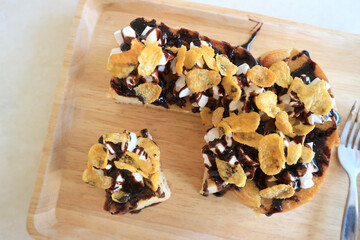 Toasts bread with cornflakes and chocolate on white wooden table
