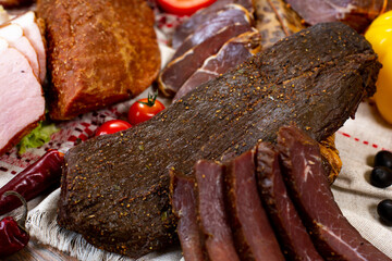 Assortment of cold cuts, a variety of processed cold meat products. On a wooden background