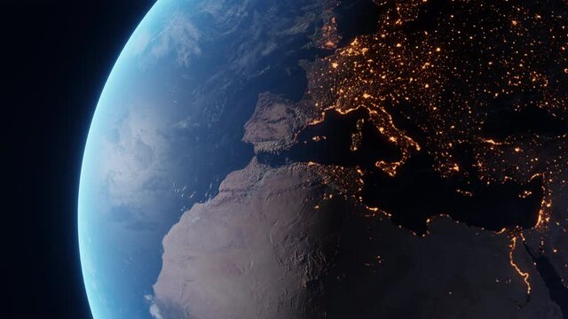 Fly over the spinning planet Earth. Day to night transition as seen from space. Glowing bright city lights shine at European continent, African continent and then North America
