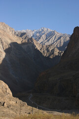 Obraz premium Pamir Highway in Gorno-Badakhshan Autonomous Region, Tajikistan. Deep Central Asia. Rocks, Blue Sly and Clouds. Untouched Nature in the Centre of Earth. Snow covered Pamir mountains.