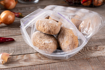 Plastic bags with frozen meat and cutlets in plastic bag on a table