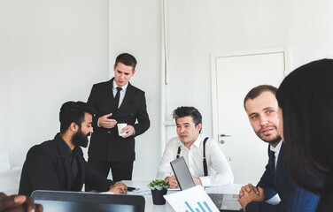 Group of young business people working and communicating while sitting at the office desk together with colleagues sitting. business meeting