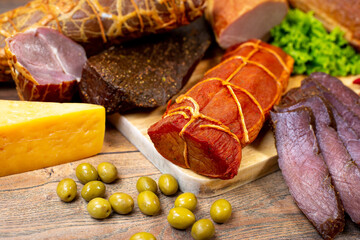 Assortment of cold cuts, a variety of processed cold meat products. On a wooden background