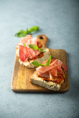 Homemade bruschetta with smoked meat and red pesto