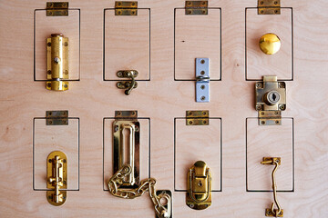 Many different locks on the wooden door. Stand with types of security systems