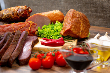 Assortment of cold cuts, a variety of processed cold meat products. On a wooden background