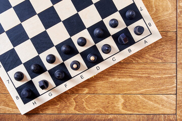 Chess board with arranged figures ready to play on the wooden table. Leisure activity and intellectual games
