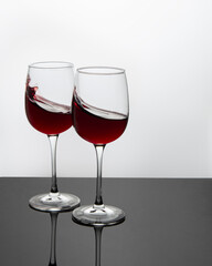 two glasses with red wine on a white background