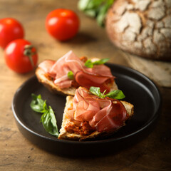 Homemade bruschetta with smoked meat and red pesto