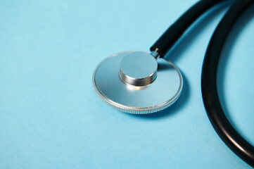 Closeup of a stethoscope on blue background with soft shadow. Copy space. Ponendoscope. Cropped view