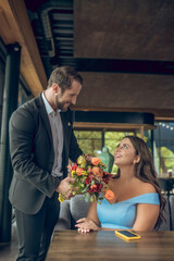 Young attractive man with bouquet and happy woman