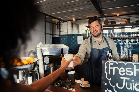 Handsome Male Barrister Serving Woman Freshly Made Hot Coffee In Funky Cafe 