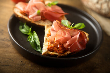 Homemade bruschetta with smoked meat and red pesto