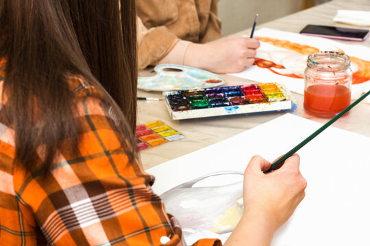 Art class in school, artist student paints in studio. Painting in classroom. Female hand with paintbrush