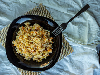 photo of pilaf in a black plate on a white background. rice dish. photo of food.  View from above. 