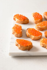 Sandwich with red caviar for festive party. Vertical format. Close up.