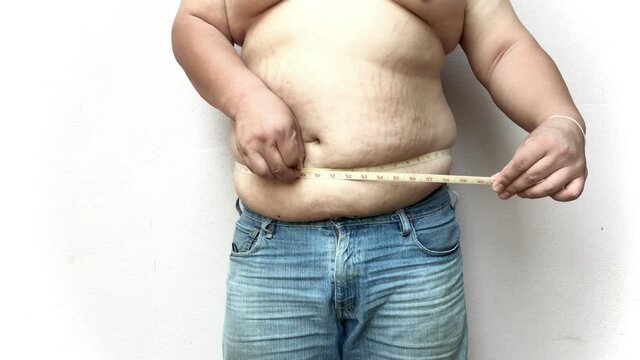 fat man check out his body fat with measuring tape.on a white background.