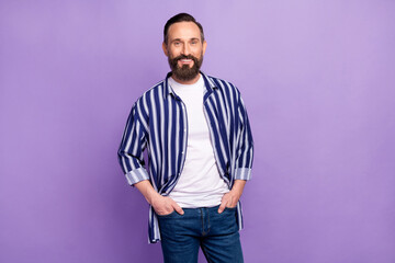 Obraz premium Photo of positive cool bearded guy hands pockets look camera wear striped shirt isolated violet color background