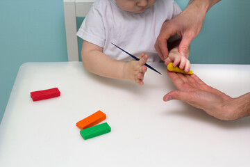 Boy playing with plasticine. Child molding modeling clay. Fine arts for toddler. Father and son together. Family time