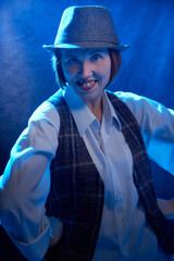 Portrait of ugle middle-aged woman with hat. Model posing in men's style in the Studio.