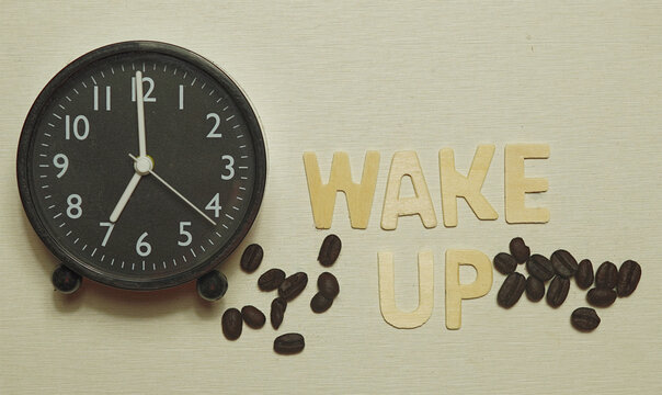 Abstract an analog clock and coffee beans and wooden letter images. Awakening concept, top view Text copy space.