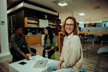 Obraz premium Caucasian woman smiling taking lunch break sitting in cafeteria while colleagues cover work the week sitting on comfy chairs in office lounge 