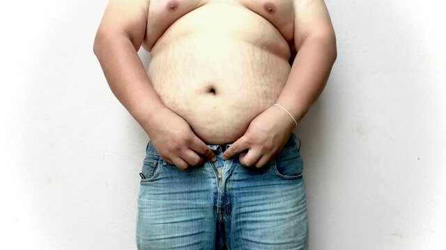 Fat man check their body fat by touching their abdomen.On a white background.Close-up.