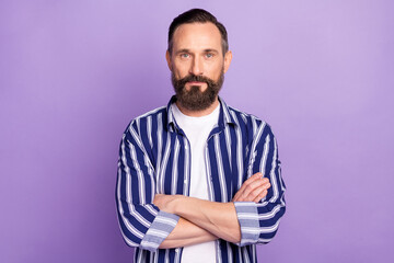 Photo of serious focused mature man crossed hands isolated over violet color background