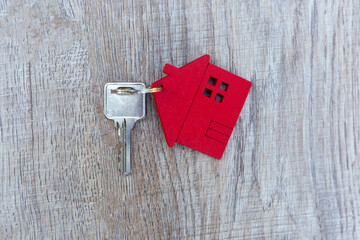The keys and the red house are placed on the table that is delivered to the customer. Mortgage, rental, purchase and home insurance concepts.