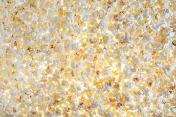 White fresh popcorn lying evenly on the surface. Popcorn back