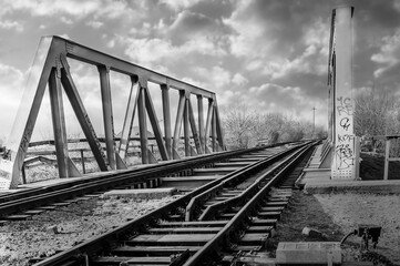 structure of gray metal railway bridge for train. Old railway bridge over the water, in black and white
