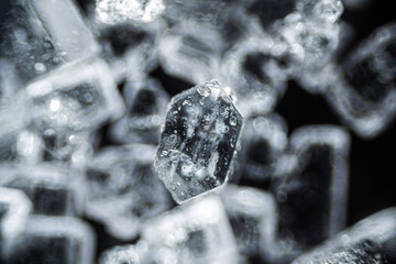 Crystal sugar close up on black background under the light microscope with a magnification of 40...