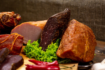 Assortment of cold cuts, a variety of processed cold meat products. On a wooden background