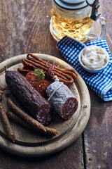 Assorted antipasti near pint of beer on rustic table