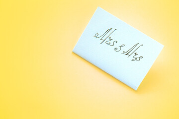 White paper card with the inscription Mrs and Mrs on yellow background. Lesbian wedding