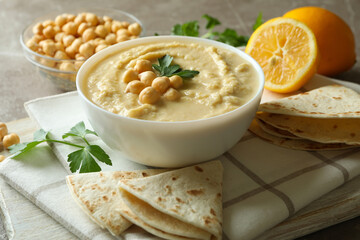 Concept of tasty eat with bowl of hummus on gray background