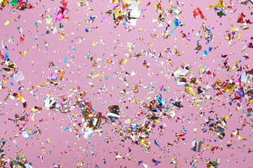 Bright colorful confetti sparkles on a pink background.