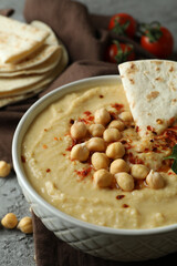 Concept of tasty eat with hummus and pita on gray background