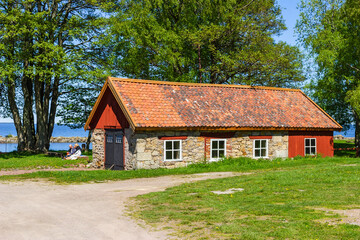 Fototapeta na wymiar Old red idyllic shed with people having picnic