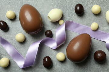 Easter chocolate eggs and candies on gray background