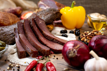 Assortment of cold cuts, a variety of processed cold meat products. On a wooden background