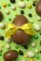 Easter chocolate eggs and candies on green background