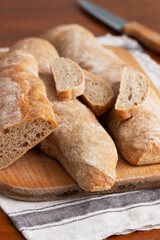 Baguette and baguette slices on a wooden table.