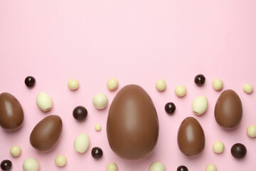 Easter chocolate eggs and candies on pink background