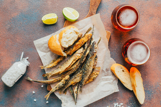 top view of fried fish, beer, baguette
