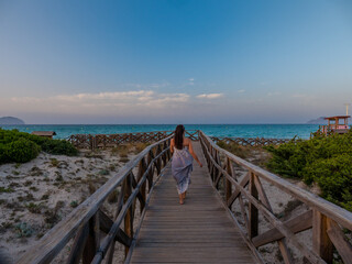 Fototapeta na wymiar girl at sunset at the beach of alcudia en majorca,balearic islands of spain