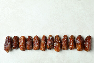 Dried dates on white textured background, space for text