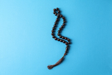 Rosary or prayer beads on blue background