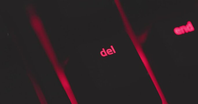 Red glowing delete key on mechanical keyboard closeup